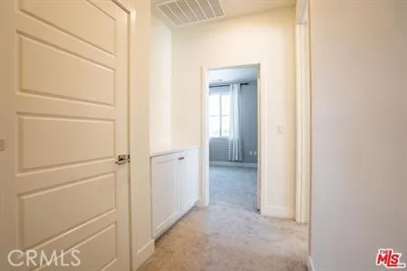 a view of a hallway with closet and a refrigerator