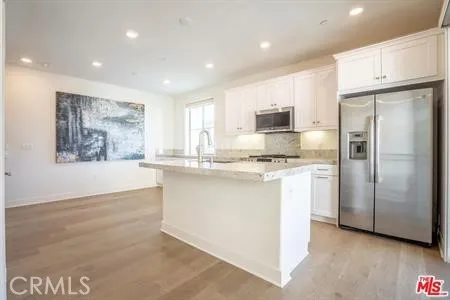 a kitchen with a refrigerator and a stove top oven