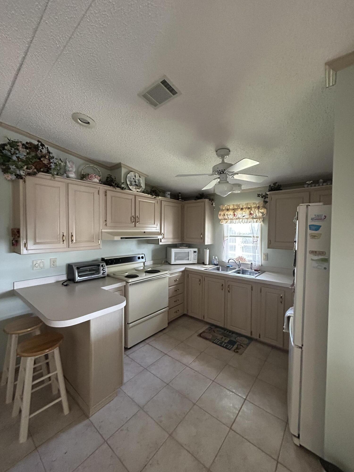 400 North Hwy A1A, Unit 47 Jupiter, FL 33477 - Photo 11 of 35 a kitchen with a sink window and cabinets