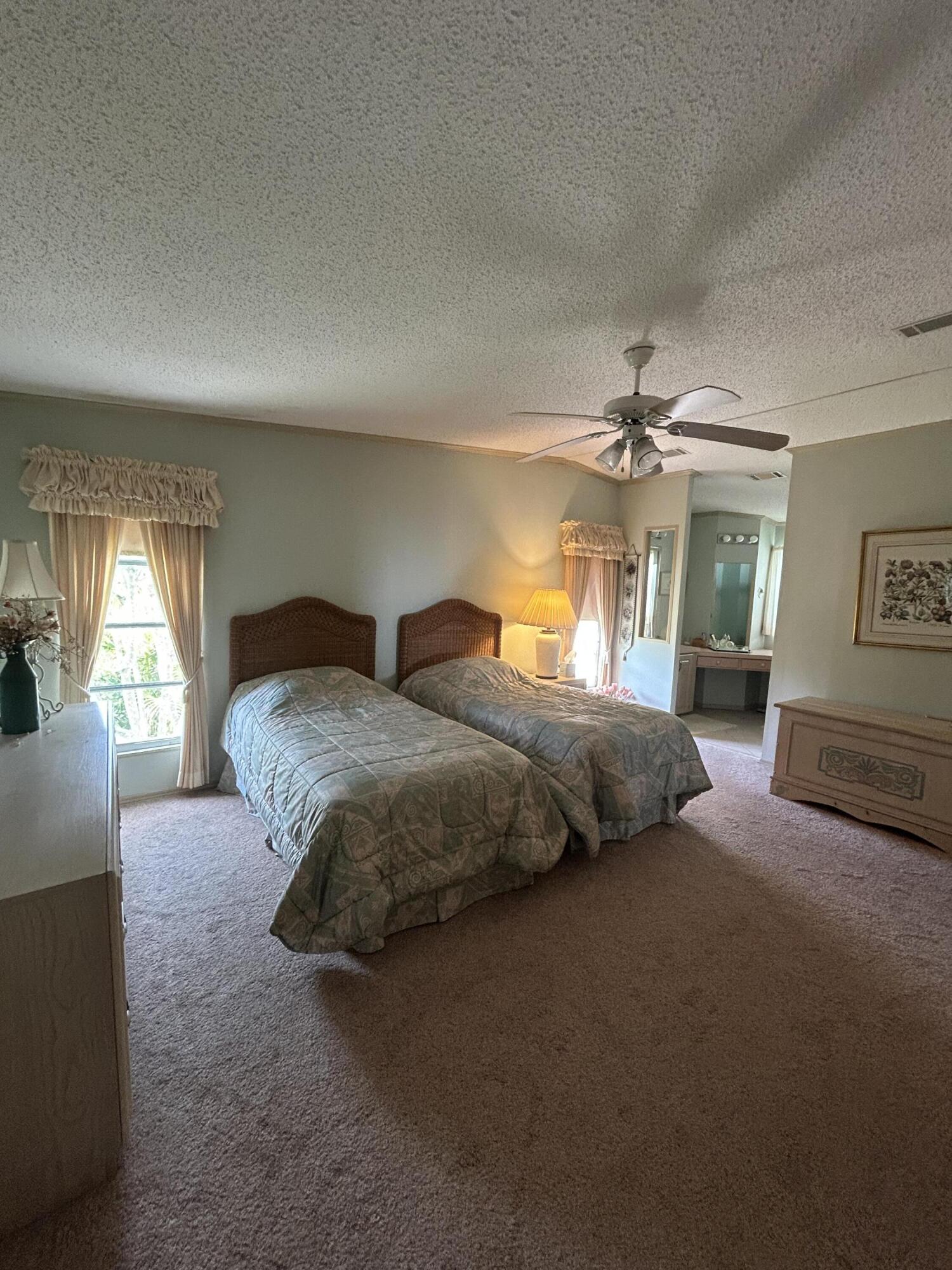 400 North Hwy A1A, Unit 47 Jupiter, FL 33477 - Photo 16 of 35 a bedroom with a bed and a chandelier