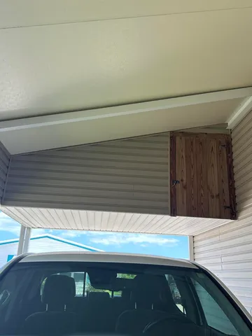 a view of backyard with wooden fence and a large tree