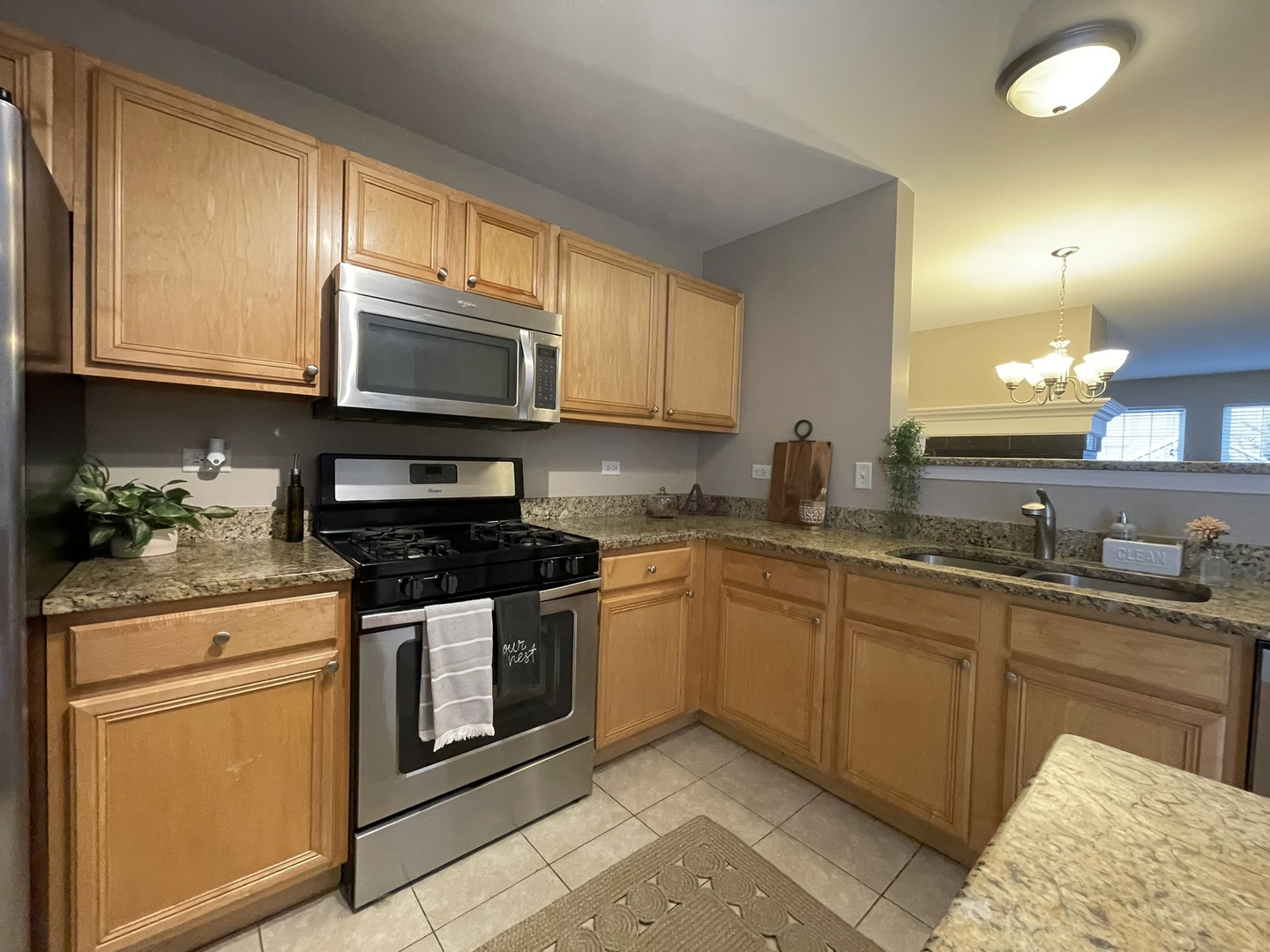 578 Triumph Court, Unit 578 Hainesville, IL 60073 - Photo 5 of 20 a kitchen with stainless steel appliances granite countertop a stove a sink and a microwave