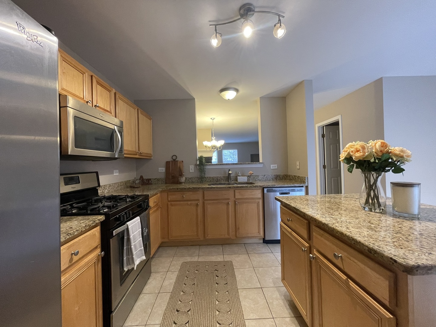 578 Triumph Court, Unit 578 Hainesville, IL 60073 - Photo 6 of 20 a kitchen with kitchen island granite countertop a sink and stove