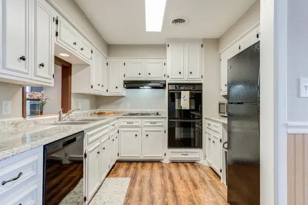 a kitchen with stainless steel appliances granite countertop a refrigerator and a stove top oven