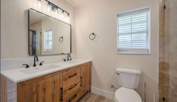 a bathroom with a toilet sink and mirror