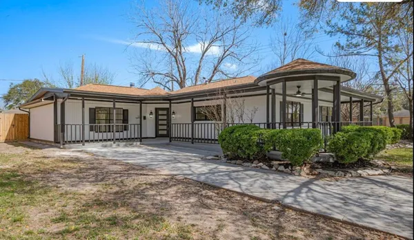 a front view of a house with yard and trees