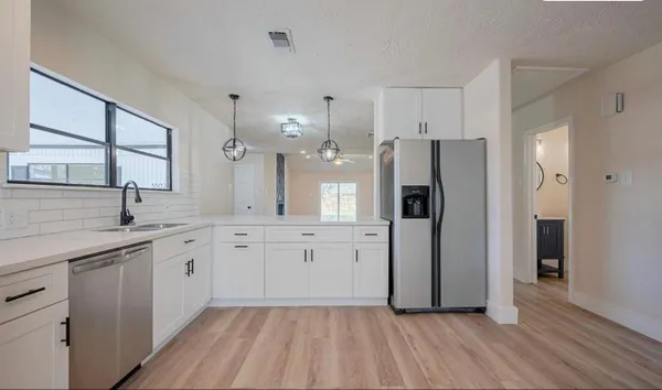 a kitchen with a refrigerator sink and cabinets