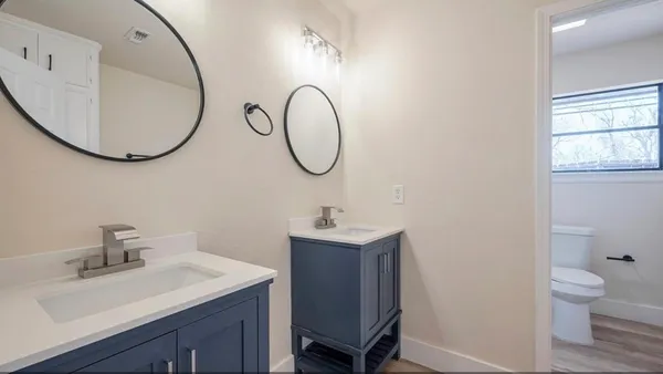 a bathroom with a sink a toilet and a mirror