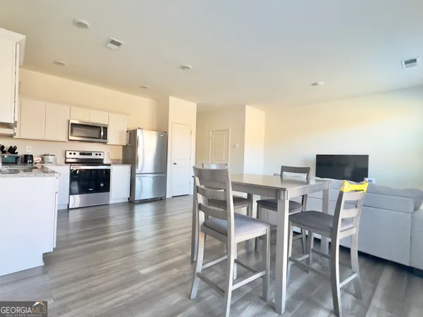 a kitchen with granite countertop a refrigerator stove top oven and sink