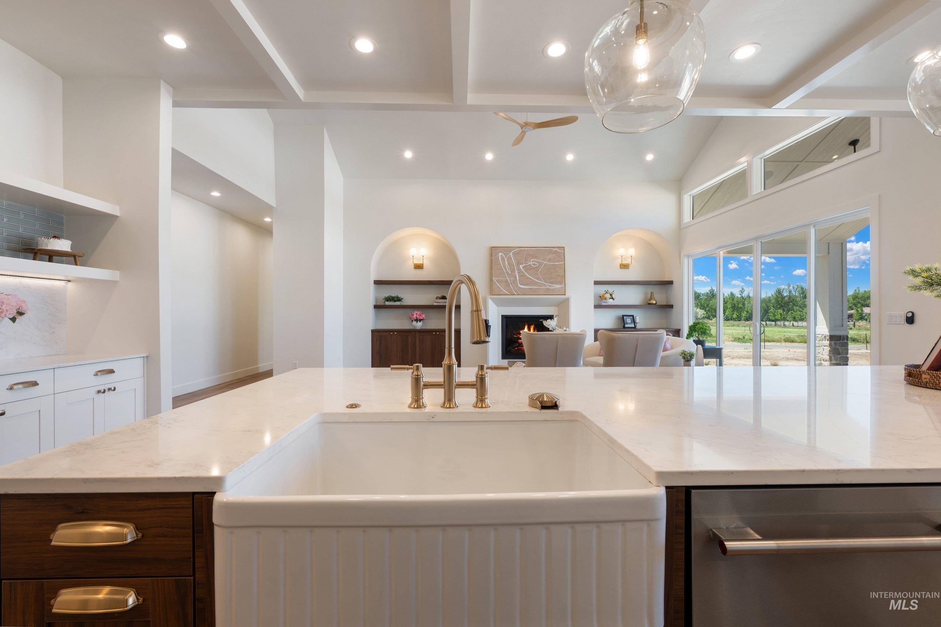 24821 Ardmore Court Caldwell, ID 83607 - Photo 17 of 43 Kitchen island featuring a white apron-front sink and brass-finish faucet