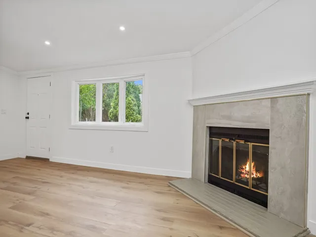 an empty room with fireplace and window