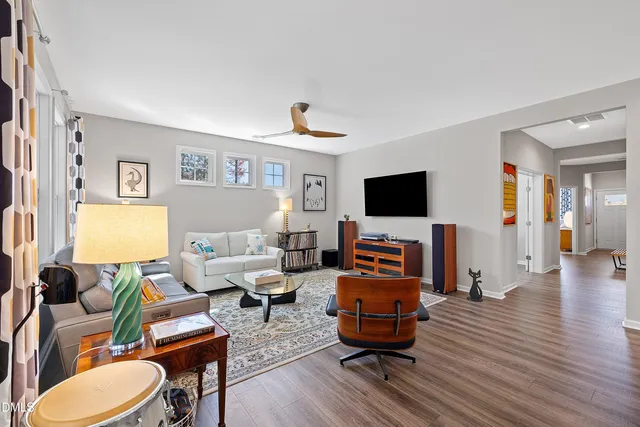 a kitchen with stainless steel appliances granite countertop a stove top oven a refrigerator a dining table and chairs with wooden floor