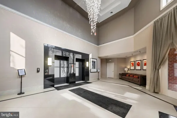 a spacious bedroom with a large bed and a chandelier