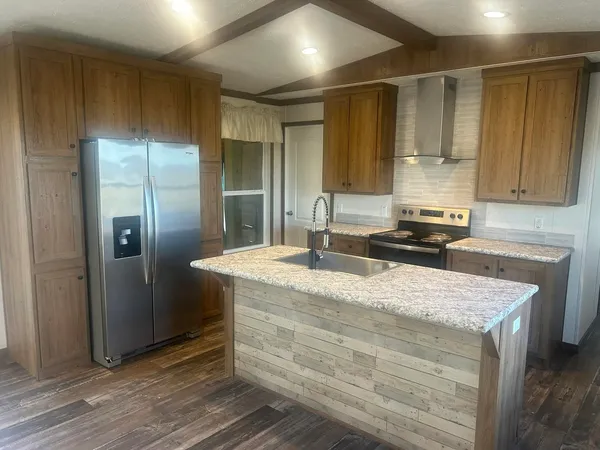 a kitchen with granite countertop a sink stove and cabinets