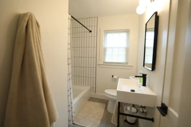 a bathroom with a sink a toilet and shower