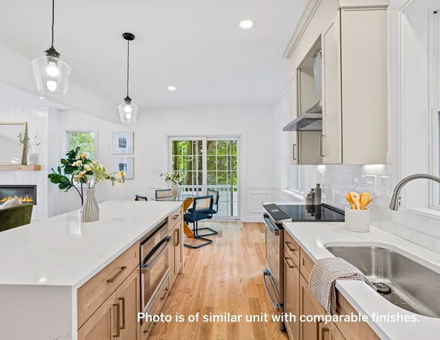 a kitchen with granite countertop a sink a counter space appliances and cabinets