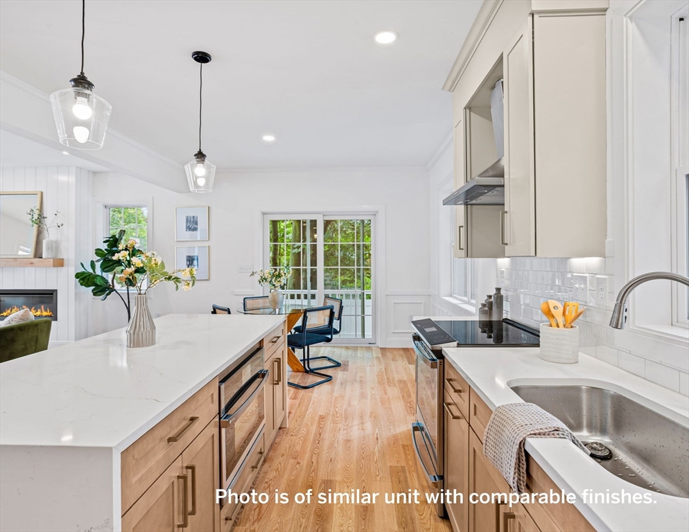 75 Franklin Street, Unit 1 Arlington, MA 02474 - Photo 11 of 36 a kitchen with granite countertop a sink a counter space appliances and cabinets