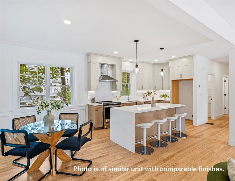75 Franklin Street, Unit 1 Arlington, MA 02474 - Photo 12 of 36 a large kitchen with kitchen island a dining table and chairs