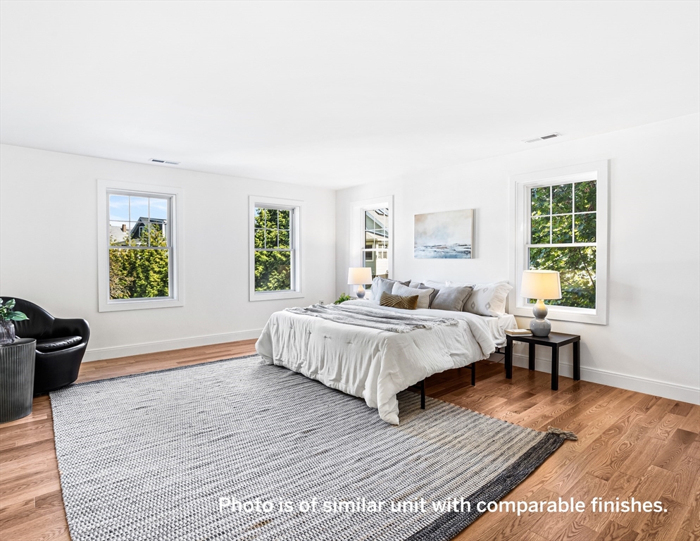 75 Franklin Street, Unit 1 Arlington, MA 02474 - Photo 20 of 36 a spacious bedroom with a bed and a table in it