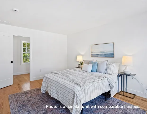 a bedroom with a bed a rug and a lamp