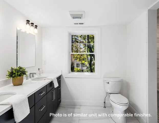 a bathroom with a sink toilet and window
