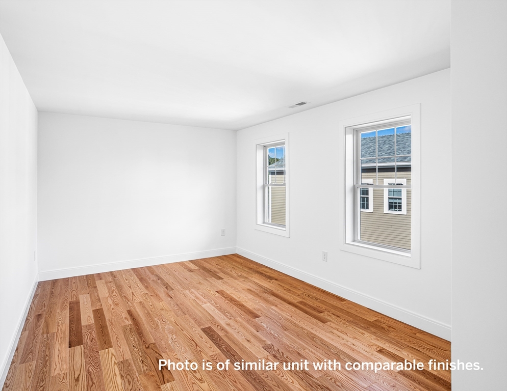 75 Franklin Street, Unit 1 Arlington, MA 02474 - Photo 26 of 36 a view of an empty room with wooden floor and a window