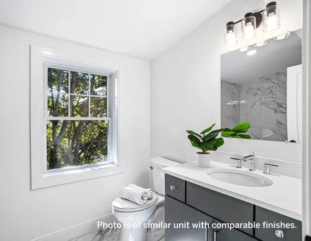 a bathroom with a sink toilet and mirror