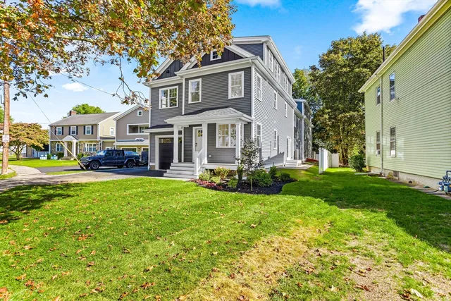 a front view of a house with yard and green space