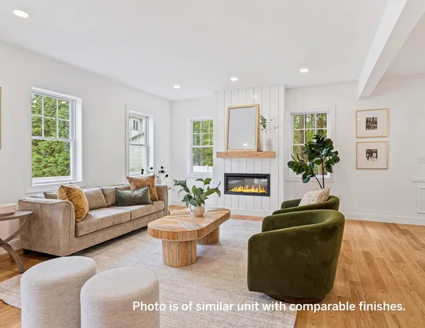 a living room with furniture a fireplace and a window