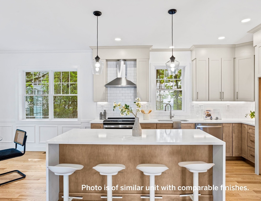 75 Franklin Street, Unit 1 Arlington, MA 02474 - Photo 7 of 36 a kitchen with kitchen island granite countertop a stove a sink a center island and a window