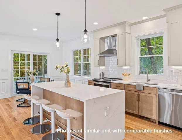 a kitchen with a sink stove and wooden floor