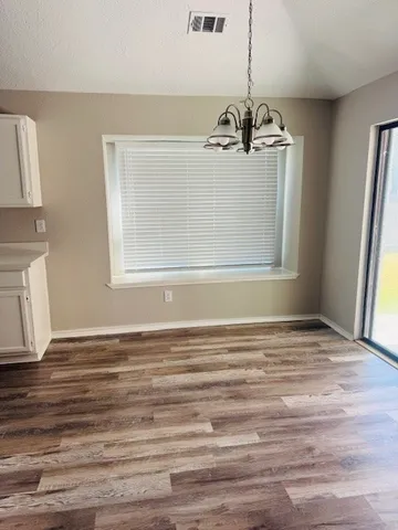 a view of a room with wooden floor and windows