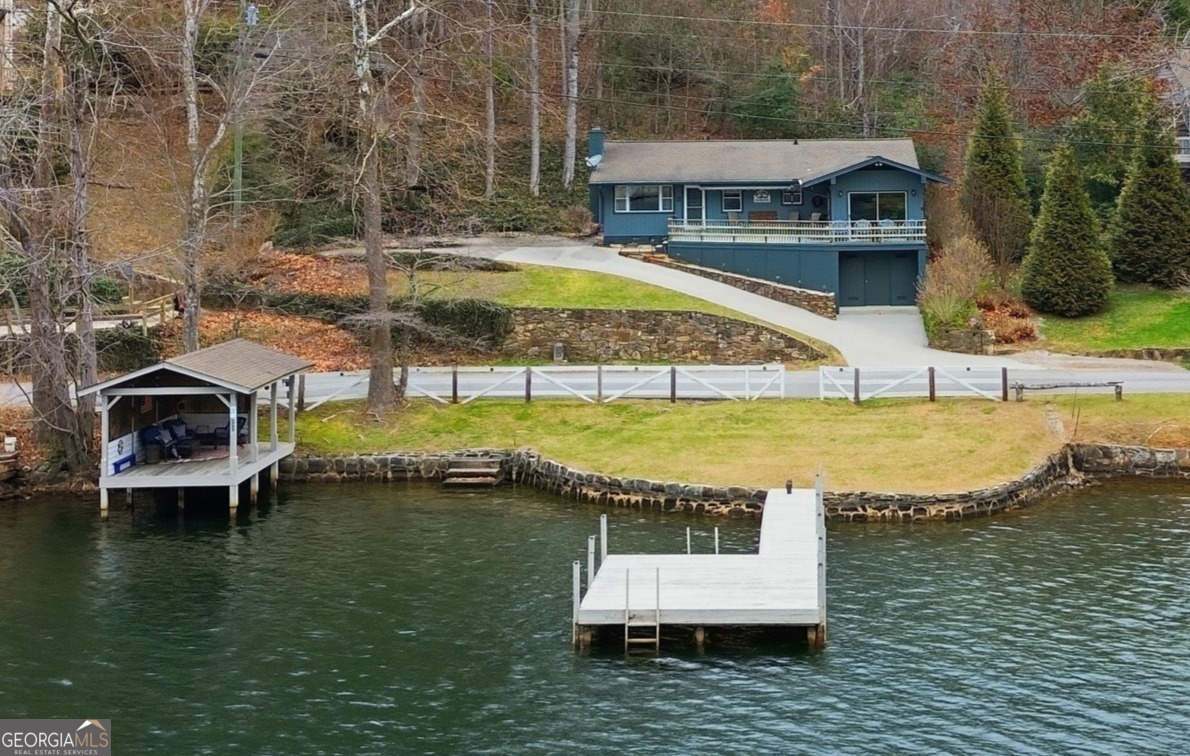 a view of a house with pool and chairs in a lake
