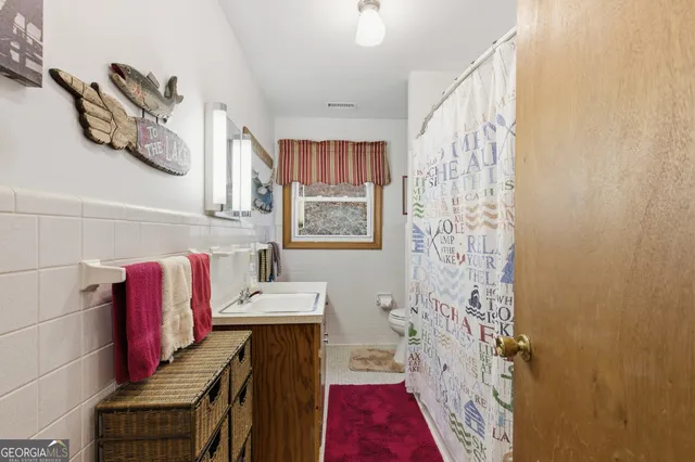 a bathroom with a sink a toilet and shower curtain