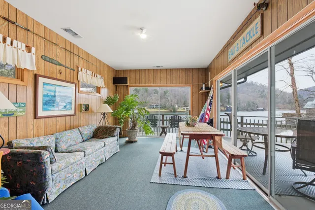 a living room with furniture a large window and wooden floor