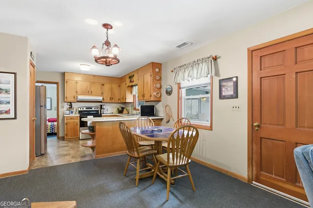 a view of a dining room with furniture and a chandelier
