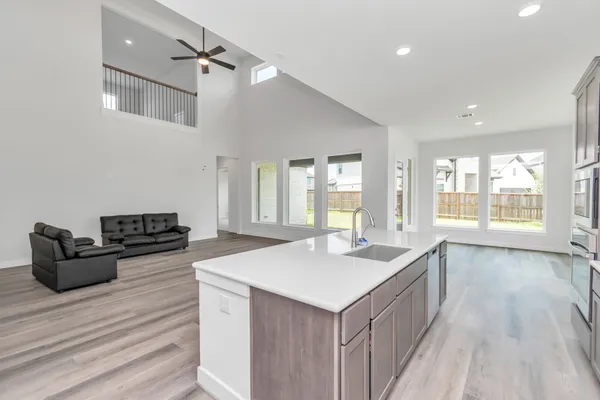 a kitchen with sink stove and wooden floor