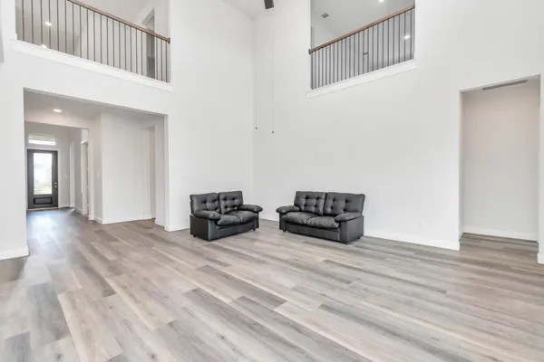 a view of a hallway with wooden floor and entryway