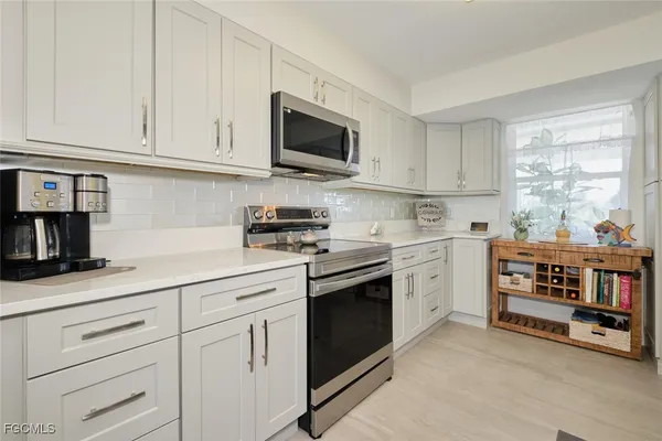a kitchen with stainless steel appliances granite countertop a sink a stove and cabinets
