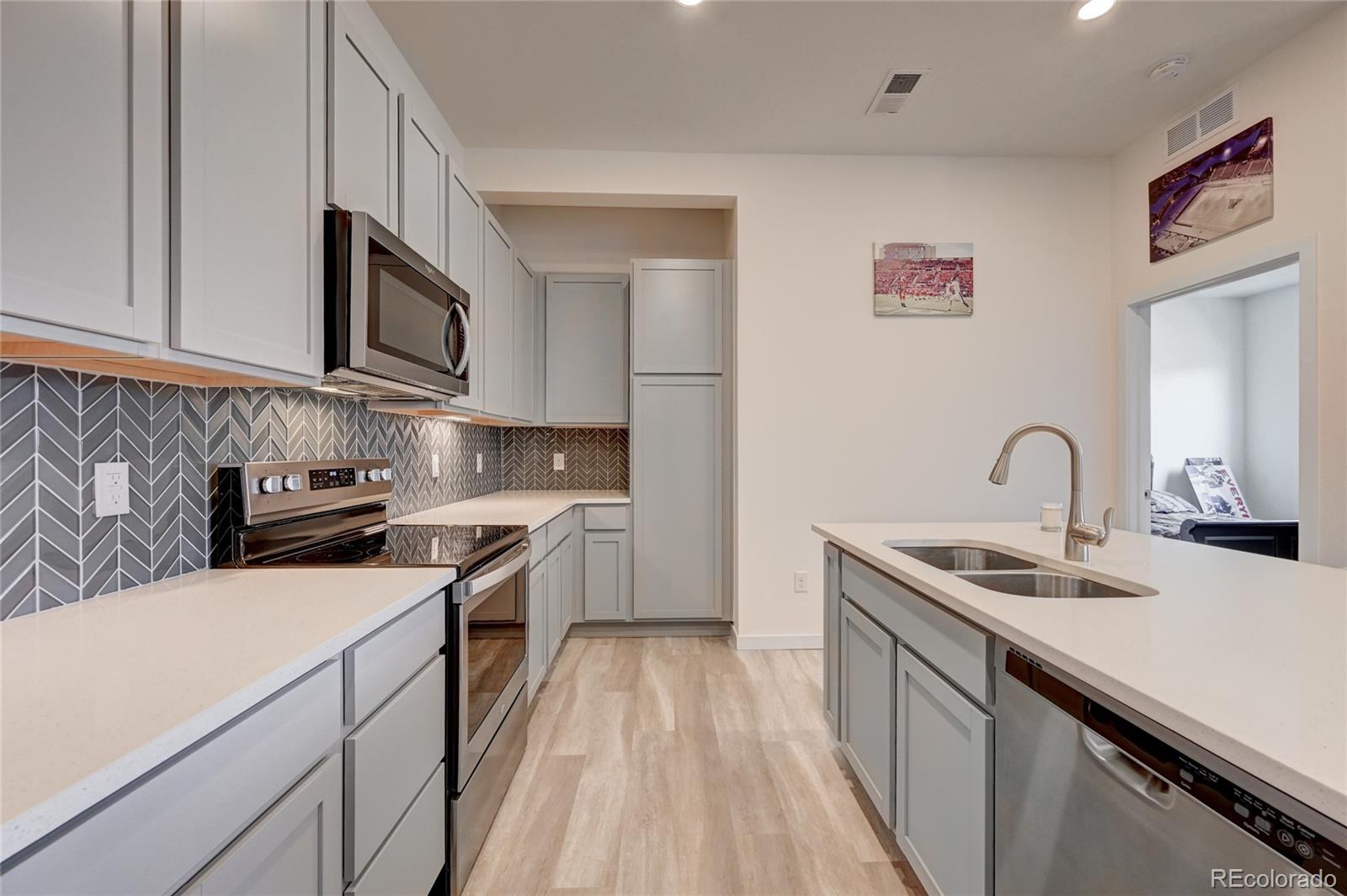 9287 Twenty Mile Road, Unit 405 Parker, CO 80134 - Photo 11 of 28 a kitchen with stainless steel appliances granite countertop a sink stove and a refrigerator