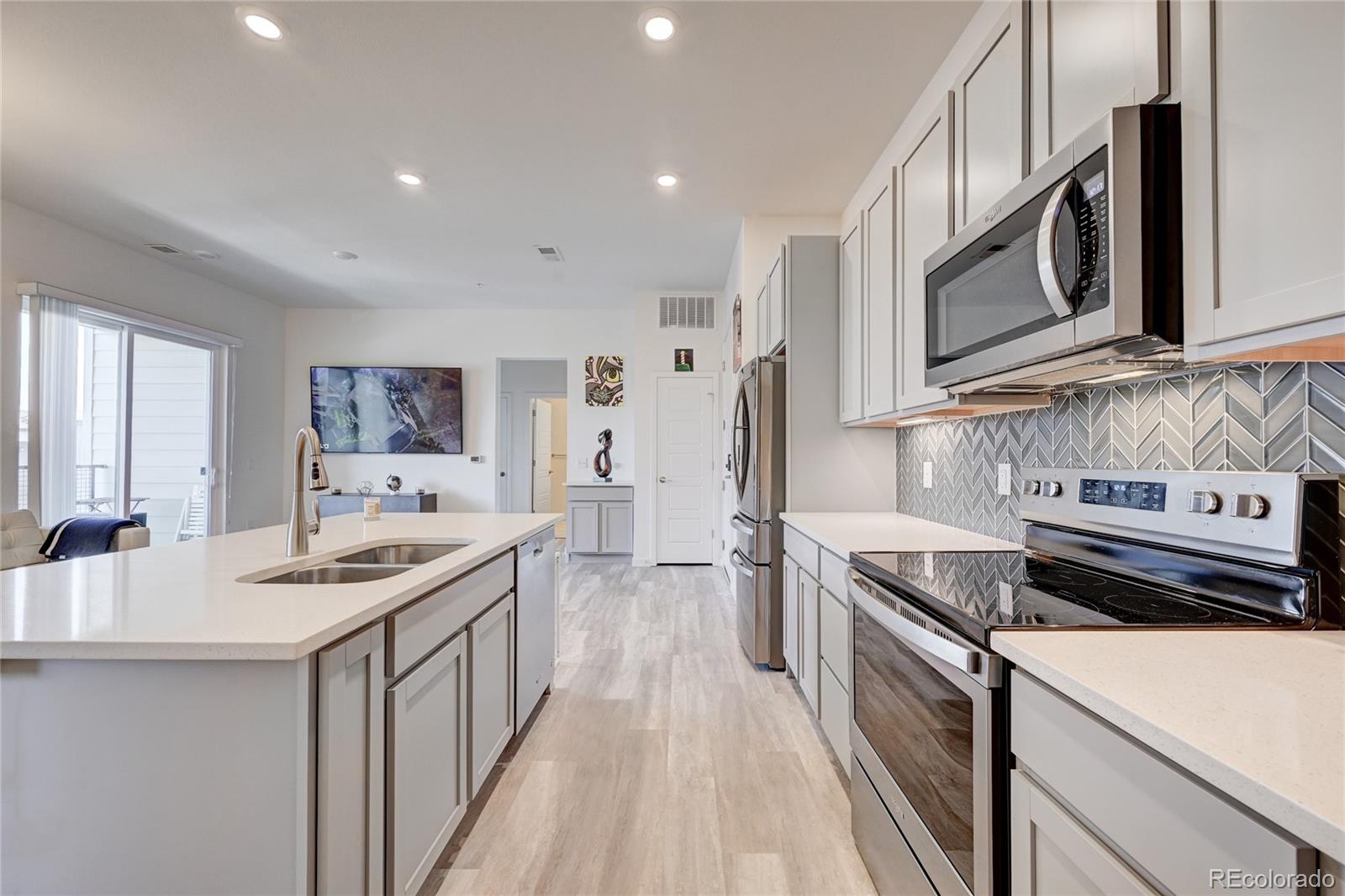 9287 Twenty Mile Road, Unit 405 Parker, CO 80134 - Photo 12 of 28 a kitchen with stainless steel appliances a stove microwave and sink
