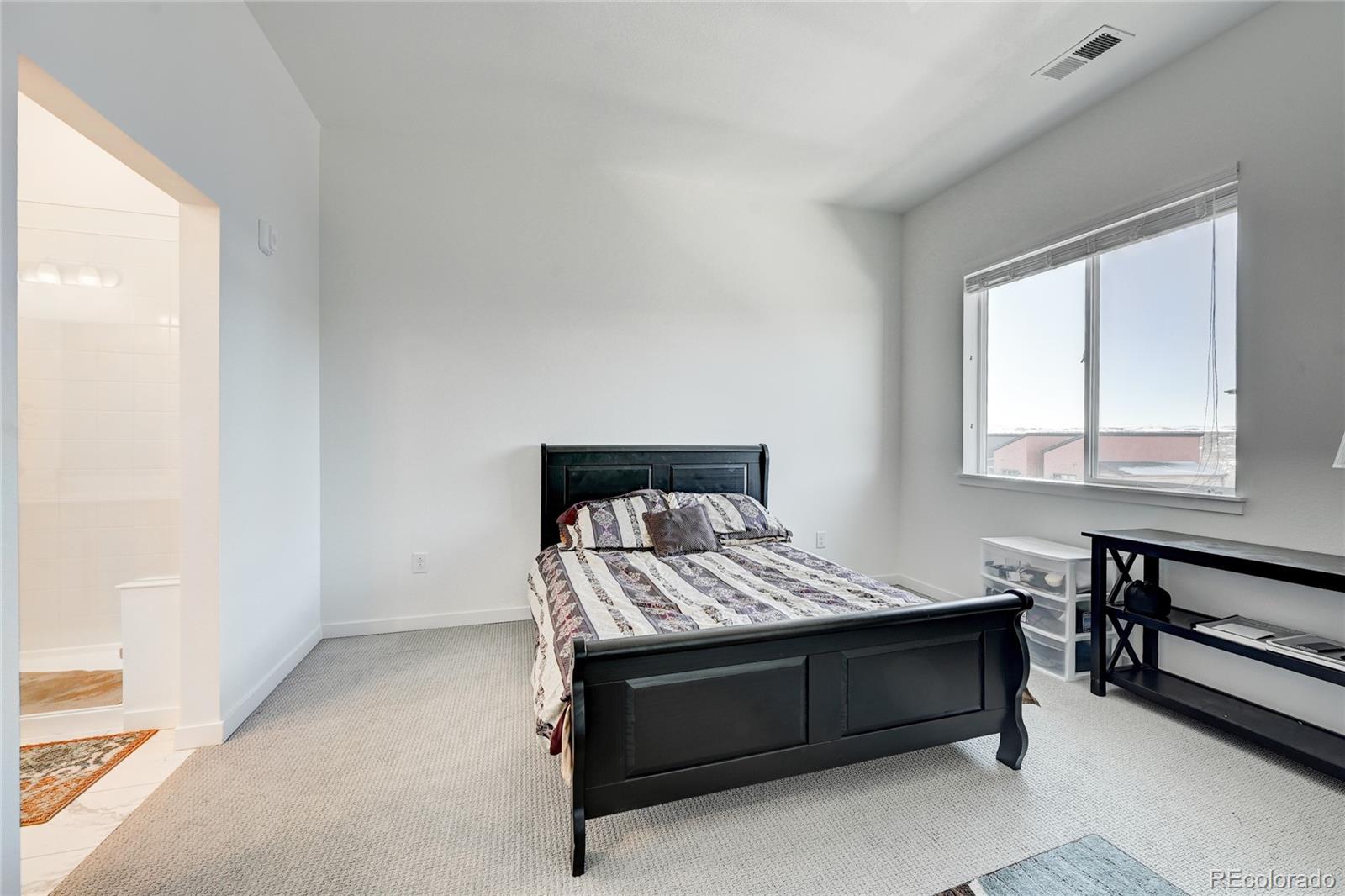 9287 Twenty Mile Road, Unit 405 Parker, CO 80134 - Photo 13 of 28 a bed sitting in a bedroom next to a window