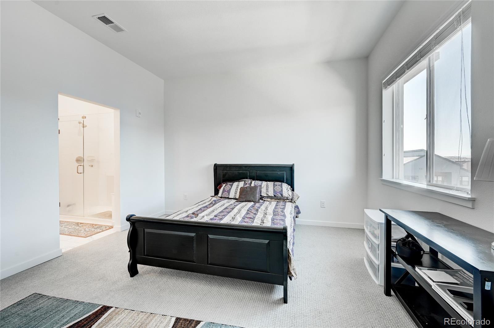 9287 Twenty Mile Road, Unit 405 Parker, CO 80134 - Photo 13 of 31 a bedroom with a bed and a window