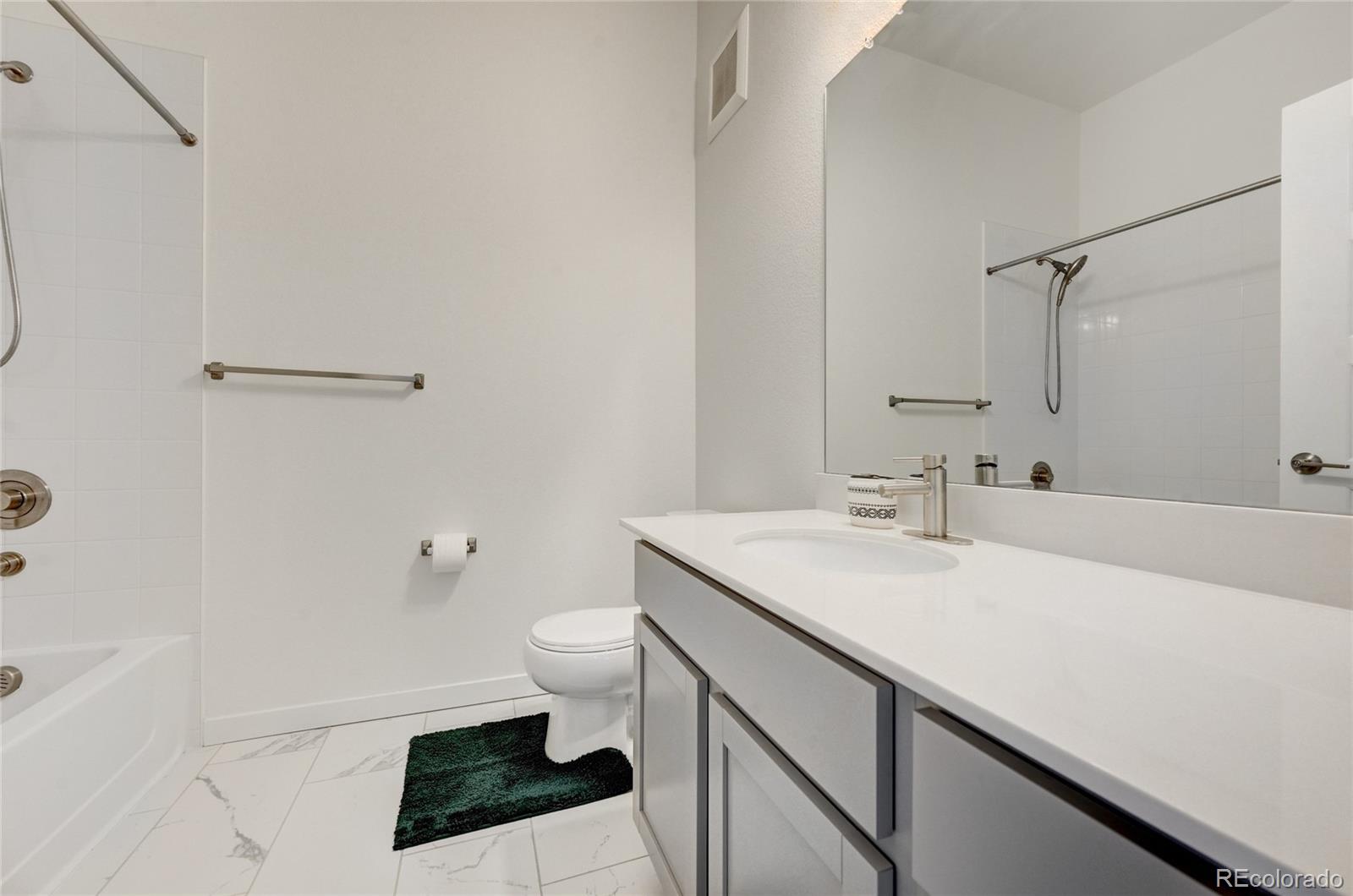 9287 Twenty Mile Road, Unit 405 Parker, CO 80134 - Photo 22 of 28 a bathroom with a sink a toilet a shower and a mirror