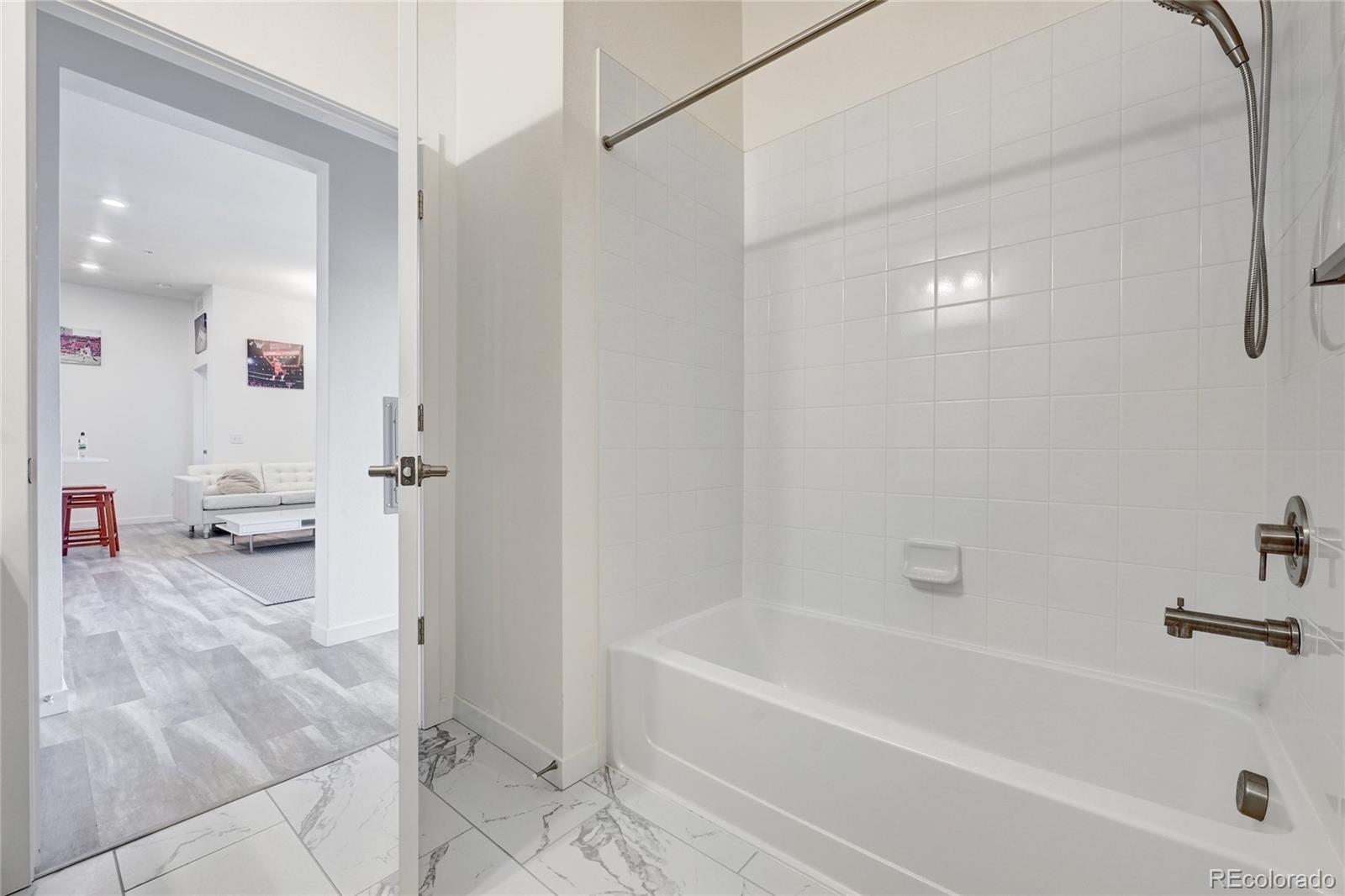 9287 Twenty Mile Road, Unit 405 Parker, CO 80134 - Photo 23 of 28 a bathroom with a bathtub and a shower