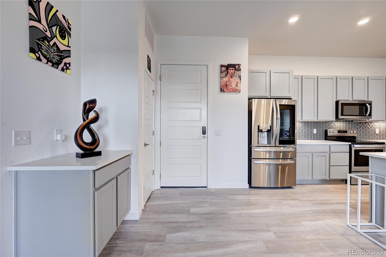 9287 Twenty Mile Road, Unit 405 Parker, CO 80134 - Photo 6 of 28 a kitchen with white cabinets and stainless steel appliances