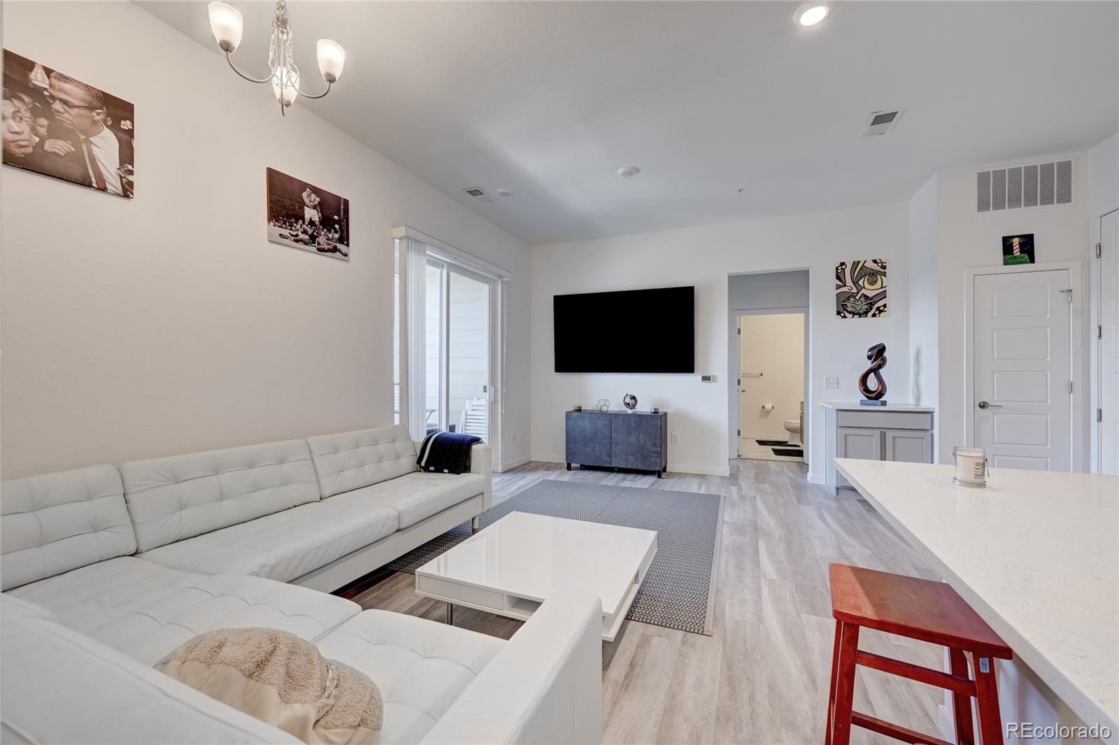 9287 Twenty Mile Road, Unit 405 Parker, CO 80134 - Photo 7 of 31 a living room with furniture and a flat screen tv