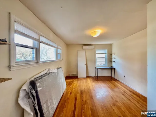 a view of a livingroom with wooden floor and a window