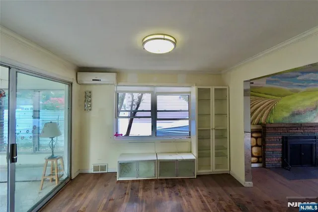 a room with wooden floor and a fireplace