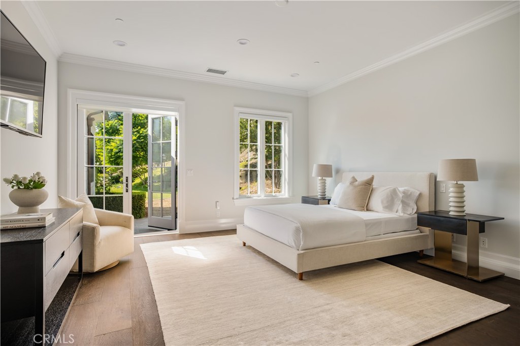 24200 Hidden Ridge Road Hidden Hills, CA 91302 - Photo 33 of 61 a spacious bedroom with a bed and a large window
